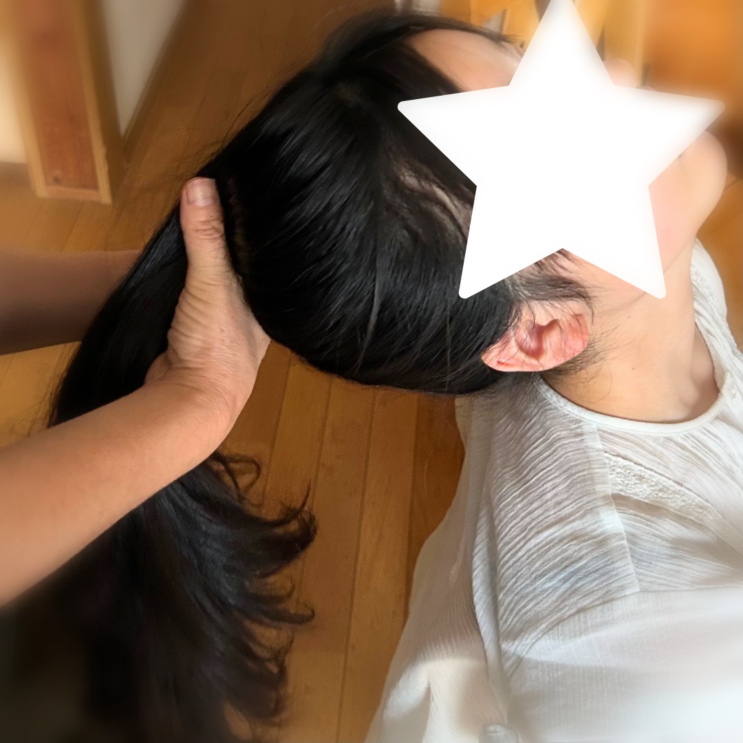 高めポニーテールを作る工程。髪を手で高い位置に持ち上げているところ